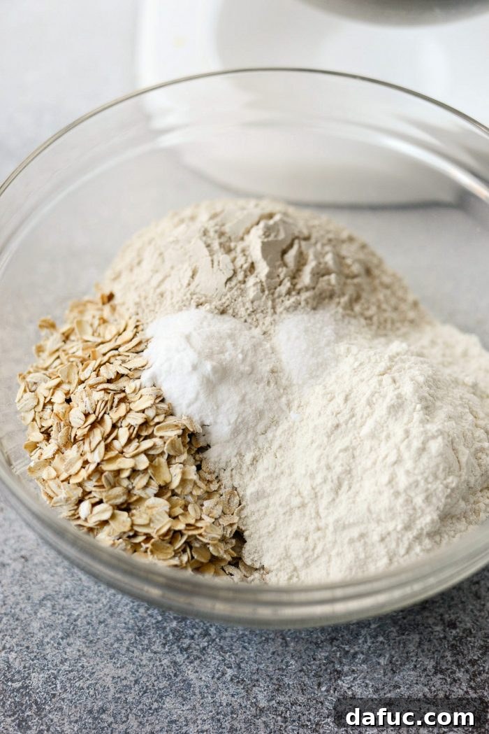 Dry ingredients like oats, flour, baking soda, and salt mixed in a bowl