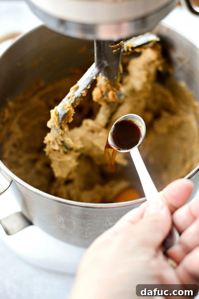 Pouring vanilla extract into the cookie dough