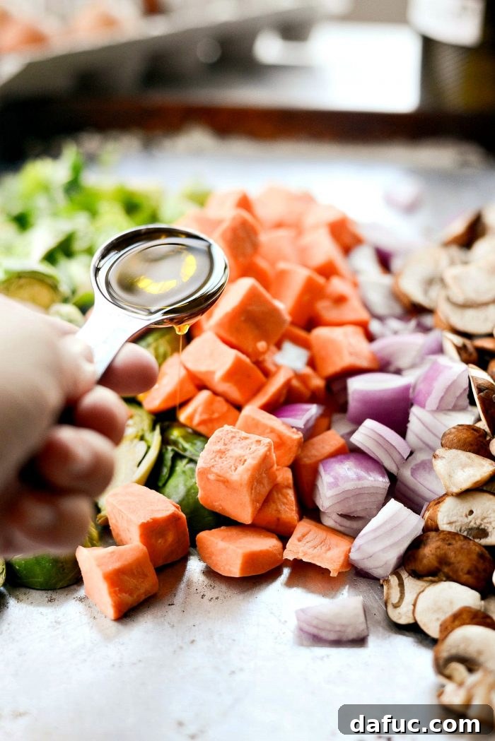 All the fresh ingredients for the Sheet Pan Breakfast Hash laid out, including Brussels sprouts, sweet potatoes, mushrooms, and red onion.