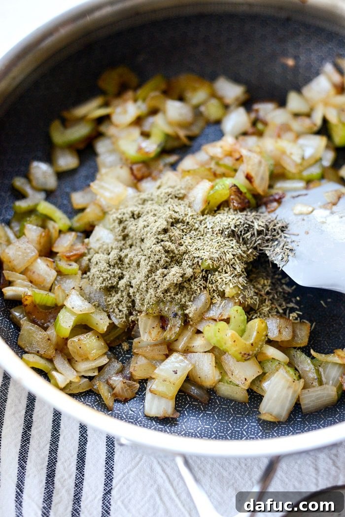 Sautéing diced yellow onion and sliced celery in a skillet.