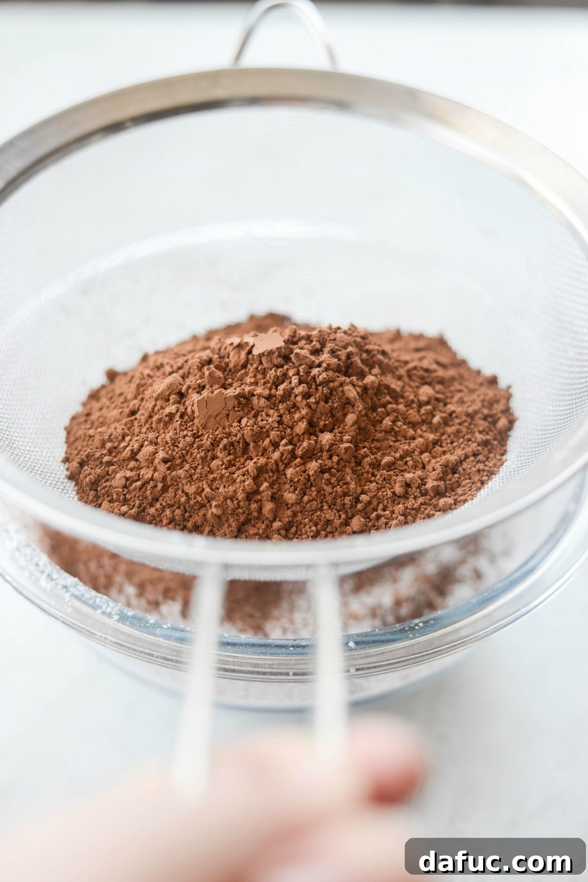 Silky Smooth Chocolate Frosting 6 Sifting powdered sugar into a large bowl for the chocolate frosting recipe.
