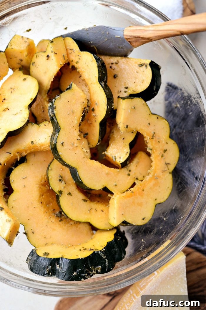 Herb Crusted Parmesan Acorn Squash 6 Herb butter coating being poured over sliced acorn squash.