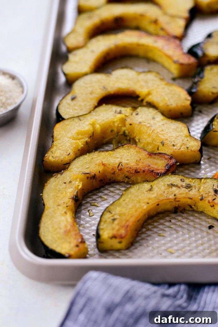 Roasted acorn squash slices after 20 minutes, ready to be flipped.