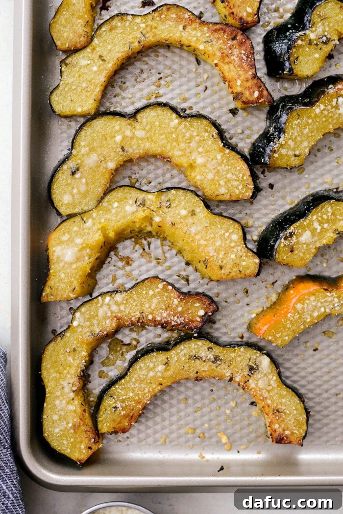 Acorn squash slices flipped and topped with Parmesan cheese.