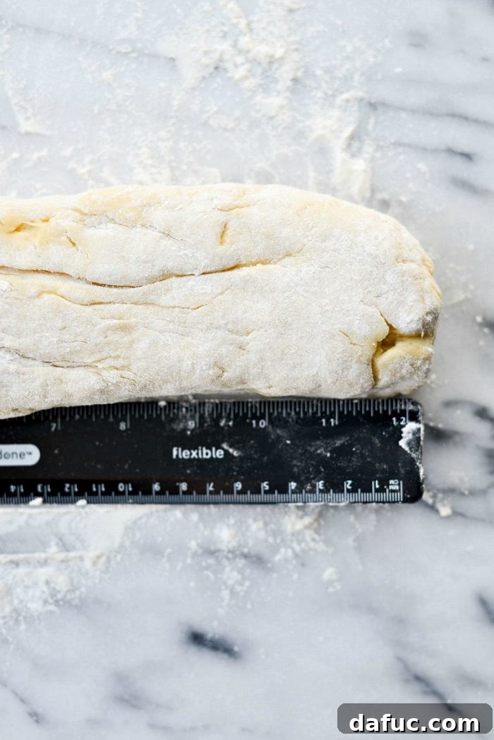 Punching down the risen dough on a lightly floured surface.