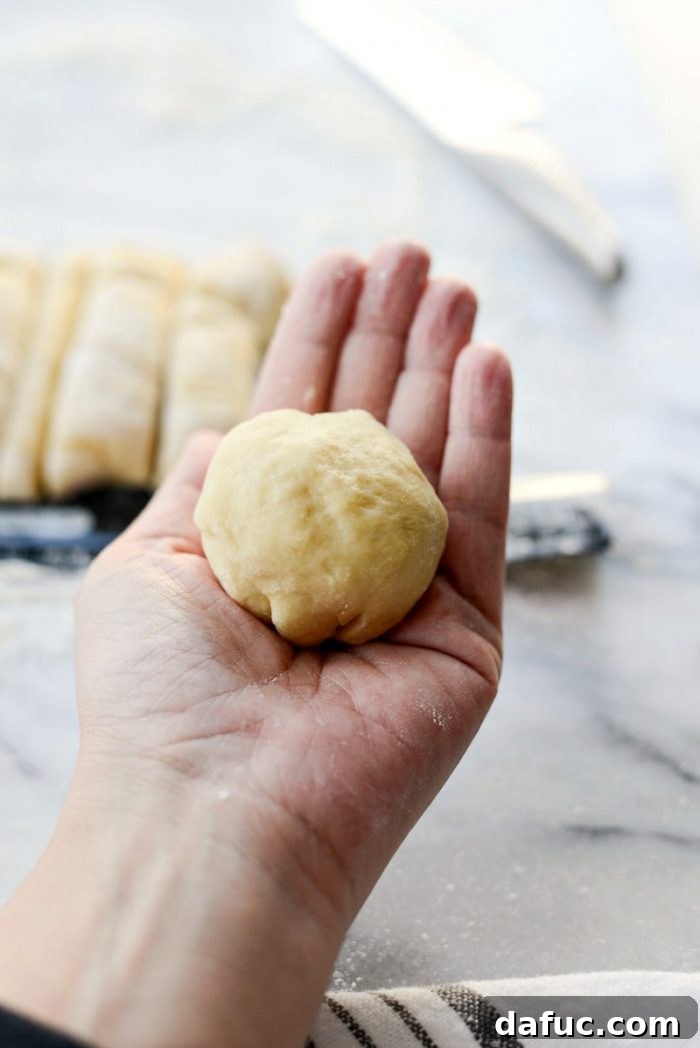 Dividing the dough log into 12 equal pieces for dinner rolls.