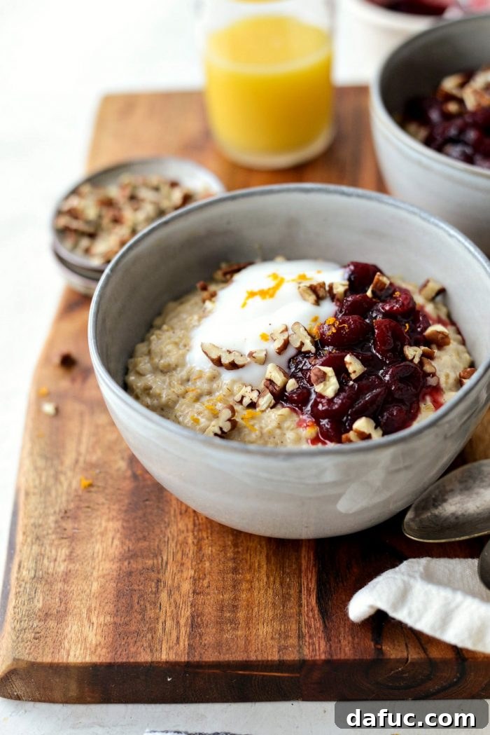 Cranberry Orange Steel Cut Oats served in a bowl, topped with cranberry sauce, vanilla yogurt, and pecans.