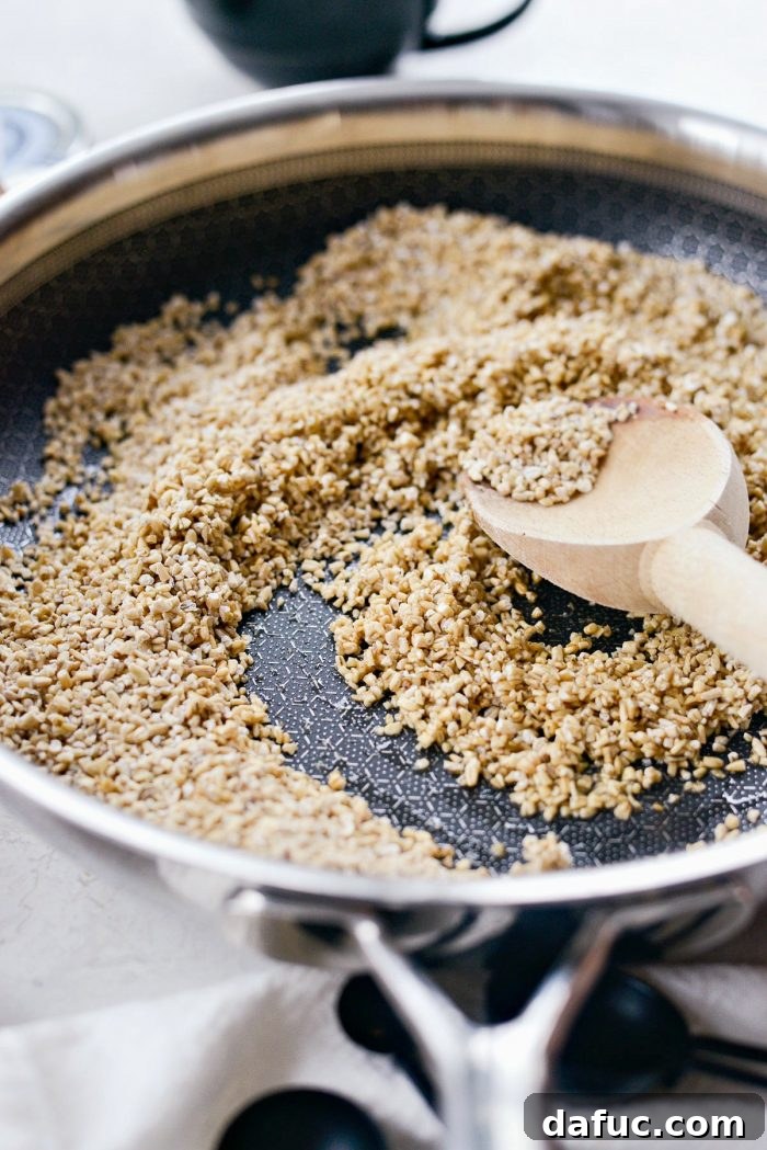 Zesty Cranberry Orange Steel Cut Oats 7 Steel cut oats added to a hot skillet for toasting.