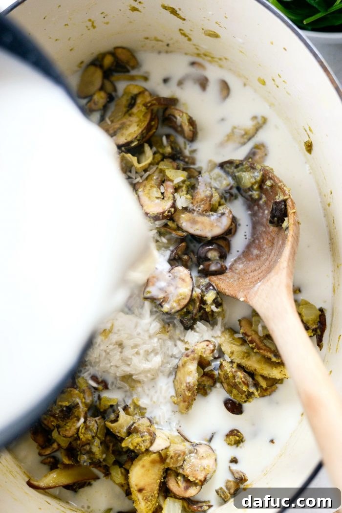 Warm chicken broth and half & half being poured into the Dutch oven, creating the creamy base