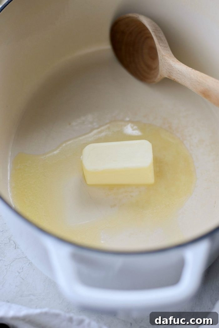 Melting butter in a Dutch oven, preparing for sautéed onions and mushrooms