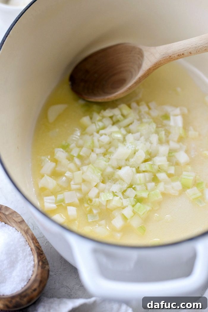 Finely diced yellow onion added to melted butter in a Dutch oven