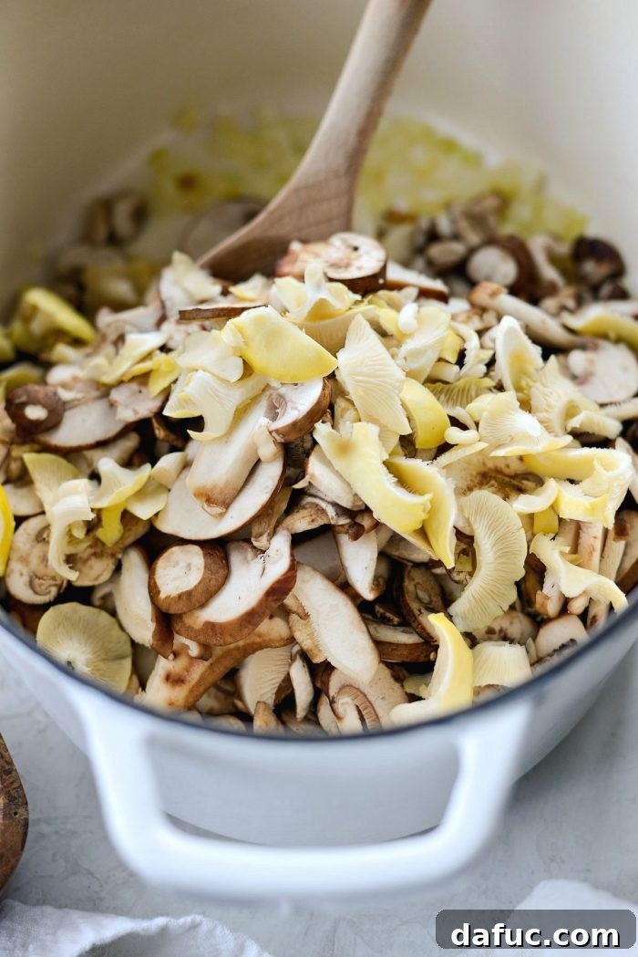 Sliced mushrooms, a blend of cremini, shiitake, and oyster, sautéing with onions