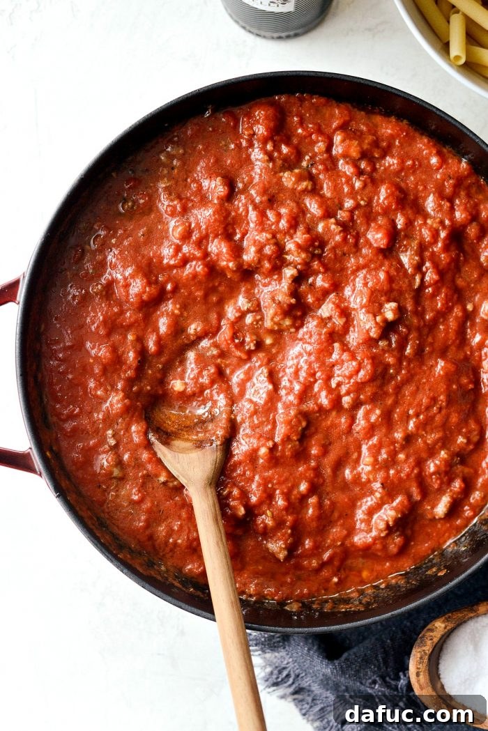 Seasoning the meat sauce with salt and pepper