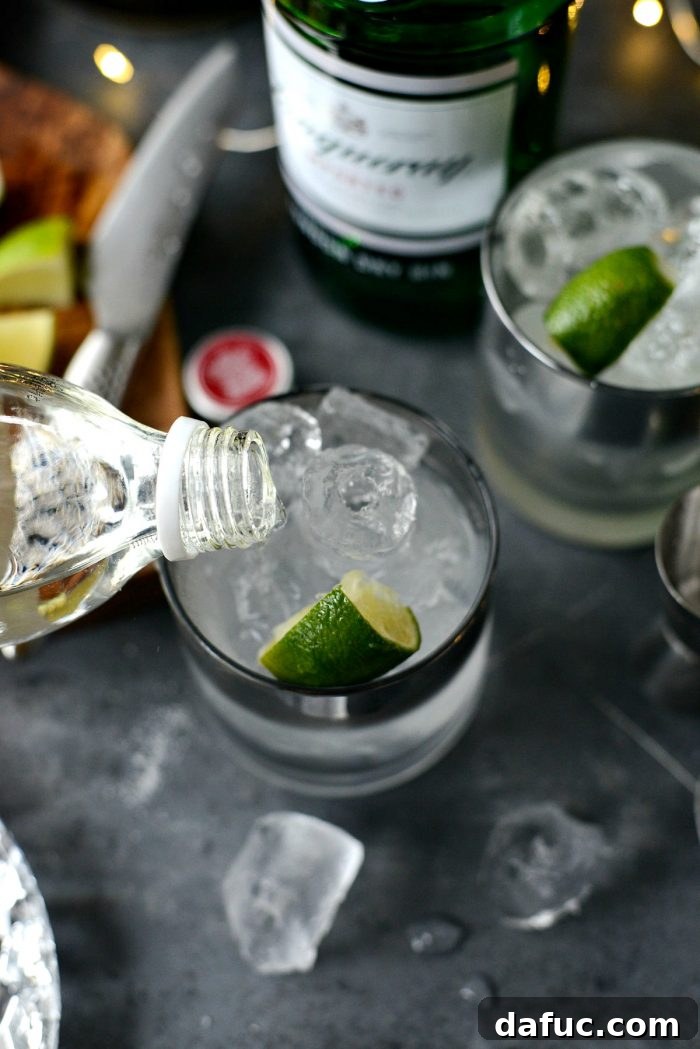 The Perfect Gin and Tonic 6 Measuring gin into a highball glass filled with ice, illustrating the precise pouring of the spirit.