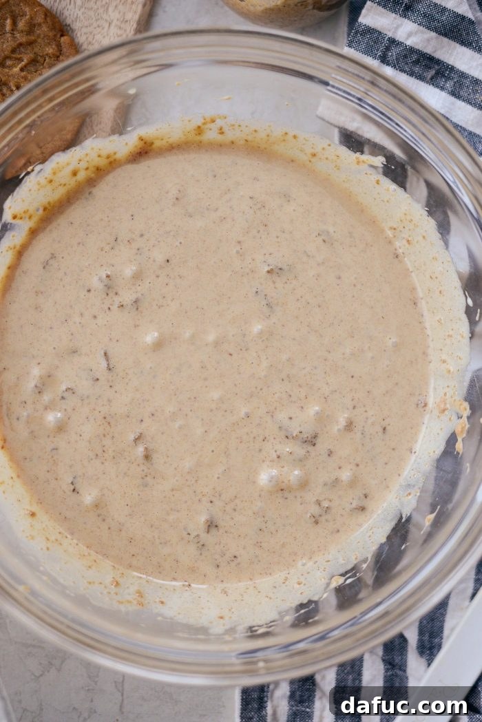 Creamy No-Churn Belgian Cookie Butter Delight 7 Combining sweetened condensed milk, cookie butter, vanilla, and crushed Speculoos cookies in a mixing bowl