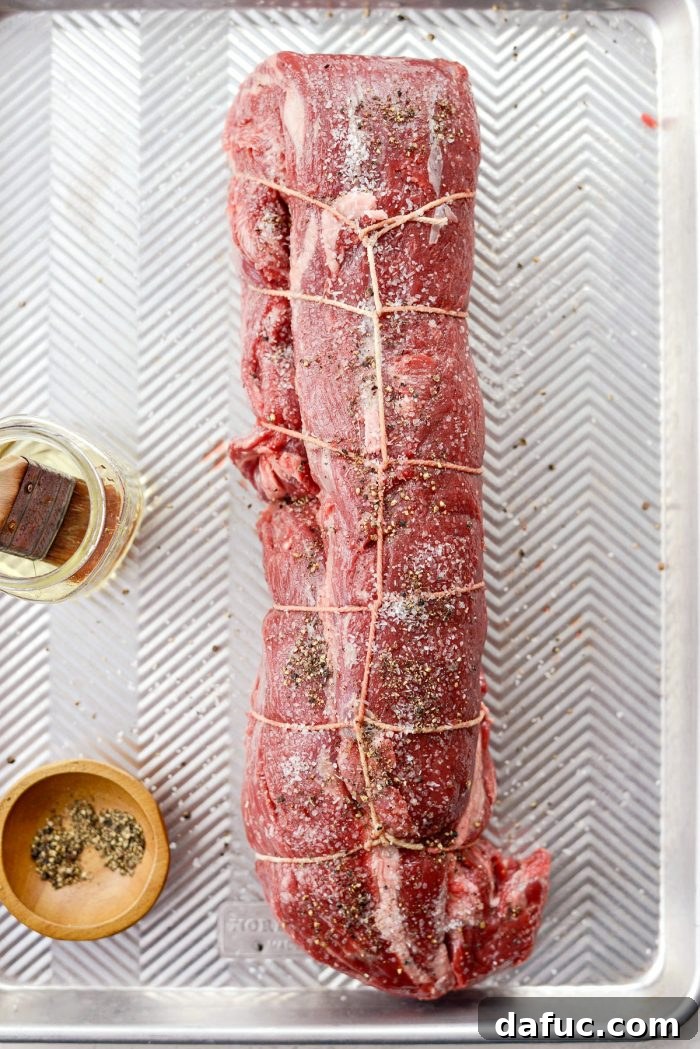 Peppercorn Crusted Beef Tenderloin 5 Seasoning beef tenderloin with oil, salt, and generous black pepper.