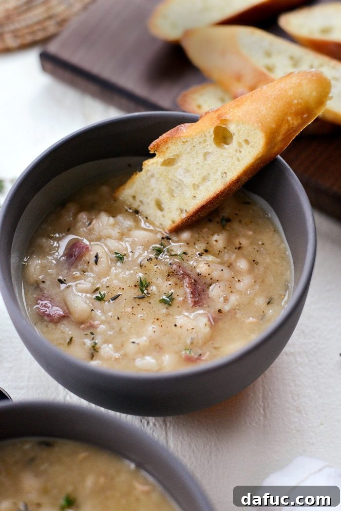 Hearty Ham and White Bean Soup 3 Close-up of hearty White Bean and Ham Soup simmering in a Dutch oven, highlighting its rich texture and ingredients.