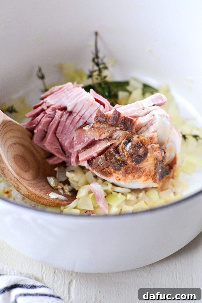 Hearty Ham and White Bean Soup 9 A leftover ham bone being added to the Dutch oven with sautéed vegetables and herbs.