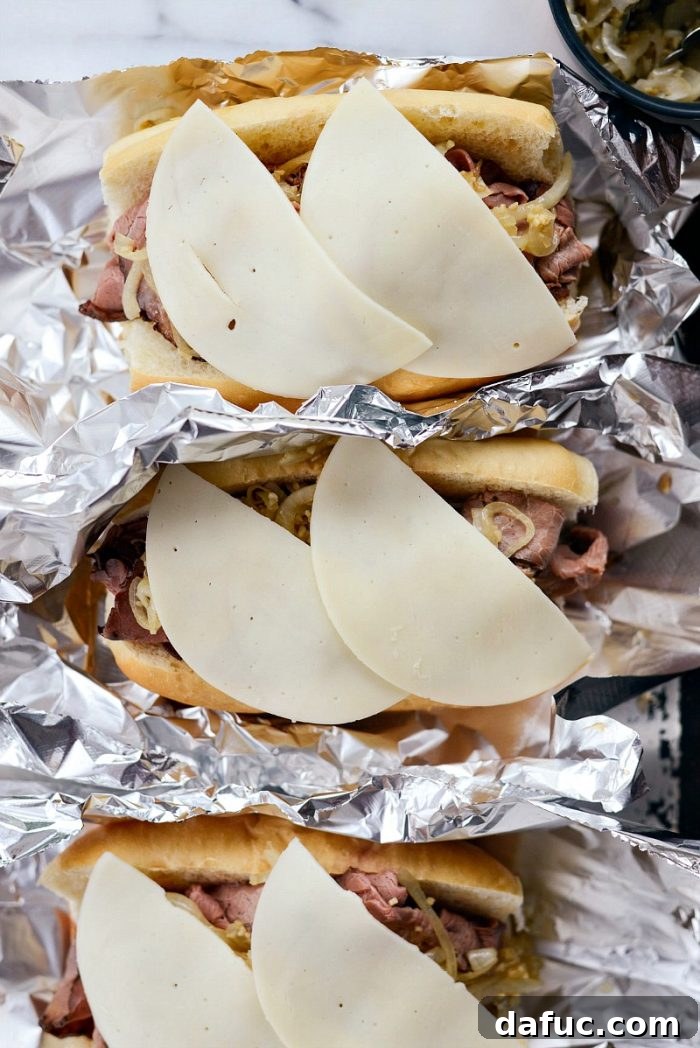 Effortless French Dip Delights 13 Sautéed onions being spooned onto the roast beef in the French Dip sandwiches
