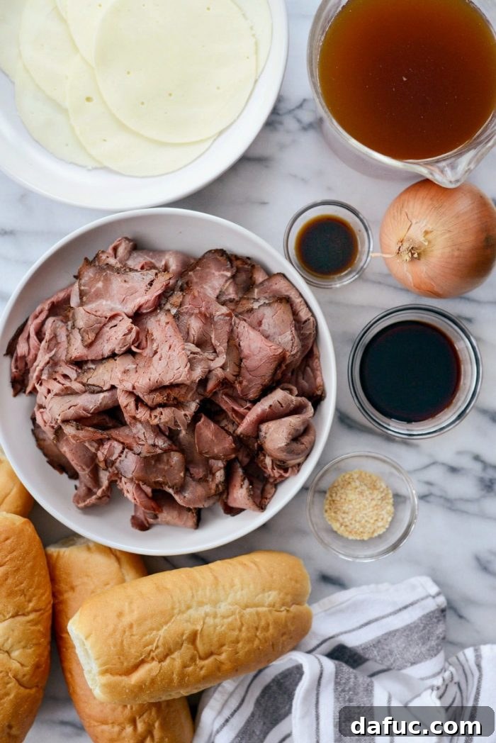 Effortless French Dip Delights 4 French Dip sandwiches arranged on a baking sheet, ready for the oven