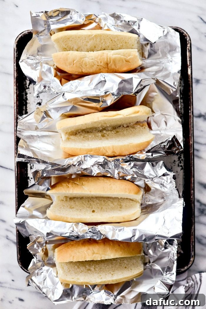 Effortless French Dip Delights 5 Ingredients for Easy French Dip Sandwiches laid out on a counter: rolls, roast beef, provolone, onion, broth