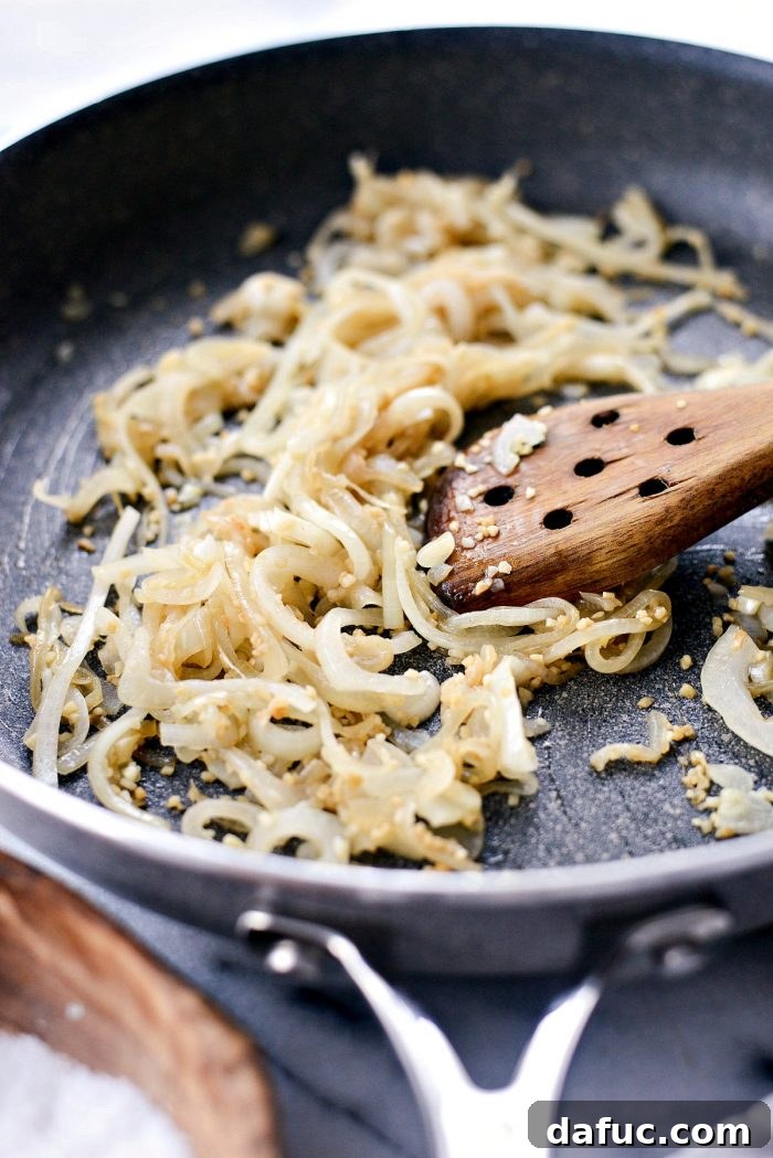 Effortless French Dip Delights 8 Thinly sliced yellow onions sautéing in a pan with garlic and salt