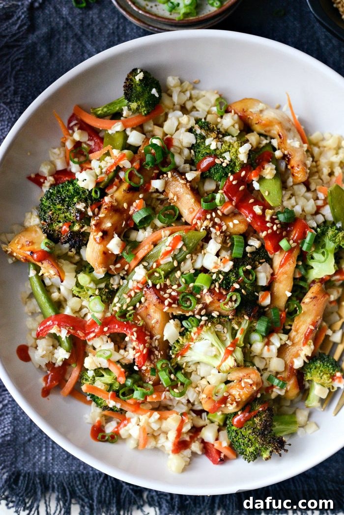 Plated Sheet Pan Teriyaki Chicken and Cauliflower Rice, garnished with fresh toppings.