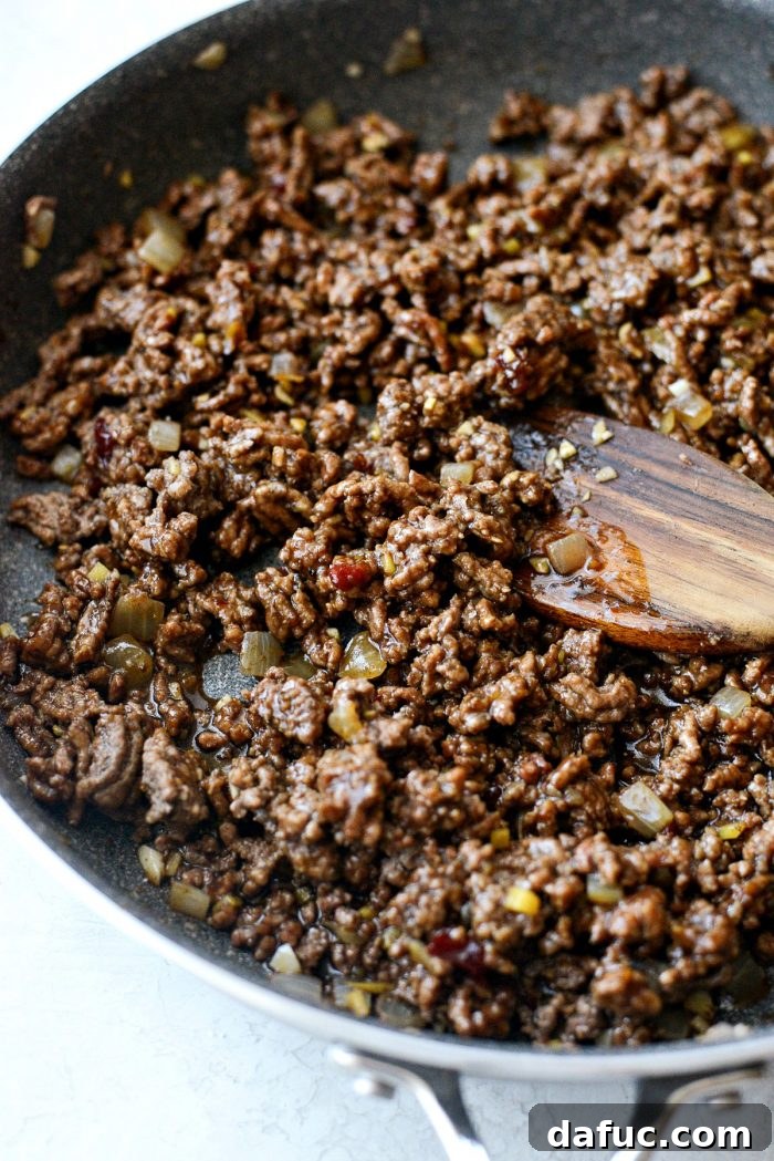 Bulgogi Power Bowls 9 Korean BBQ sauce being stirred into ground beef, creating a rich and flavorful mixture