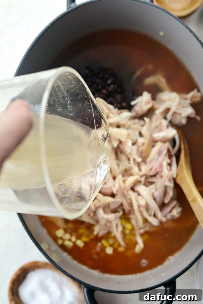 Effortless Chicken Tortilla Soup Delight 10 Fresh lime juice being squeezed into the simmering chicken tortilla soup.