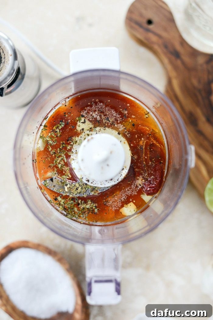Sweet Heat Chipotle Vinaigrette 4 All the fresh ingredients for Chipotle Honey Vinaigrette laid out on a wooden cutting board, including lime, garlic, chipotle peppers, and herbs.