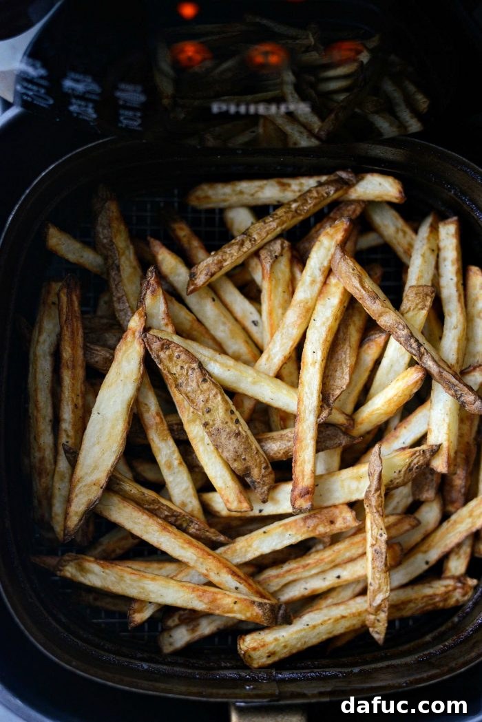Crispy Homemade Air Fryer Fries 11 Several batches of golden, crispy air fryer French fries piled high on a wire rack