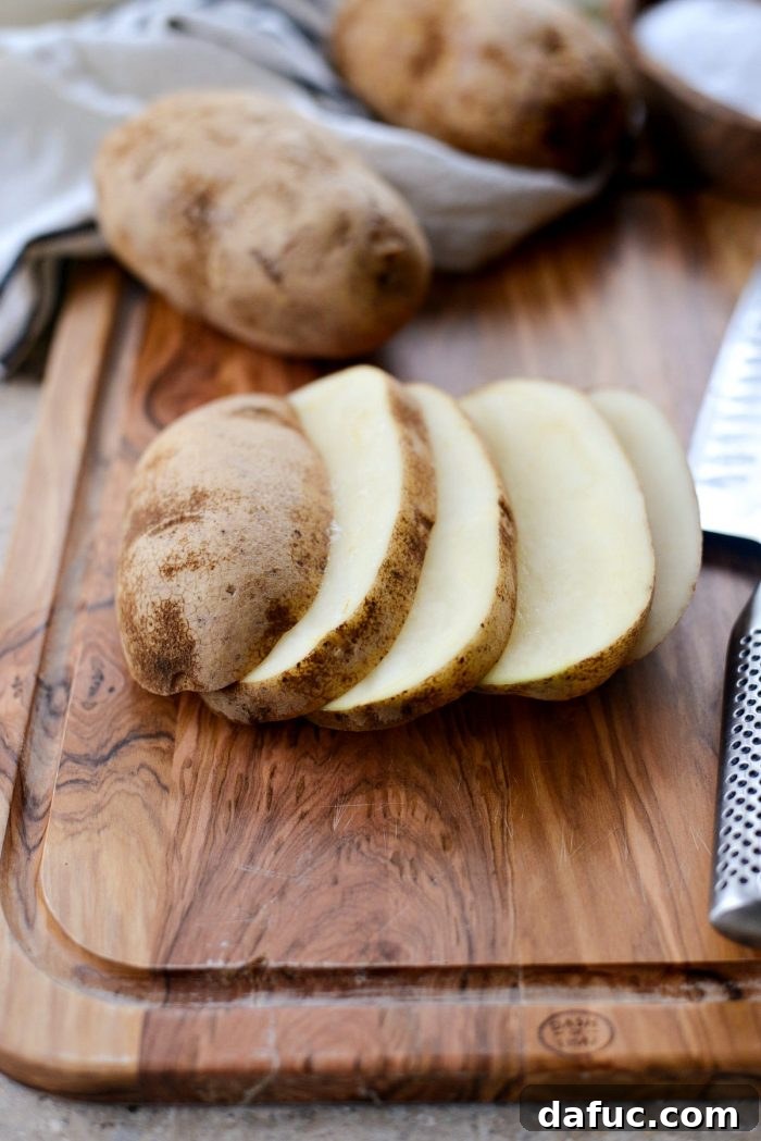 Crispy Homemade Air Fryer Fries 5 Pile of thinly sliced Russet potatoes, ready for cutting into fries