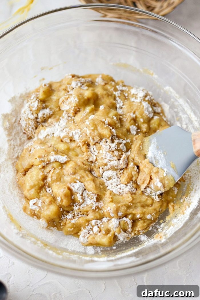 Cream Cheese Swirled Banana Bread 11 Stirring mashed bananas into wet ingredients