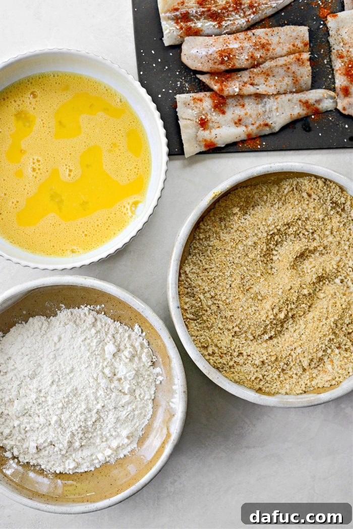 Golden Crispy Fish Sandwiches 9 Breading station setup with flour, egg wash, and breadcrumbs
