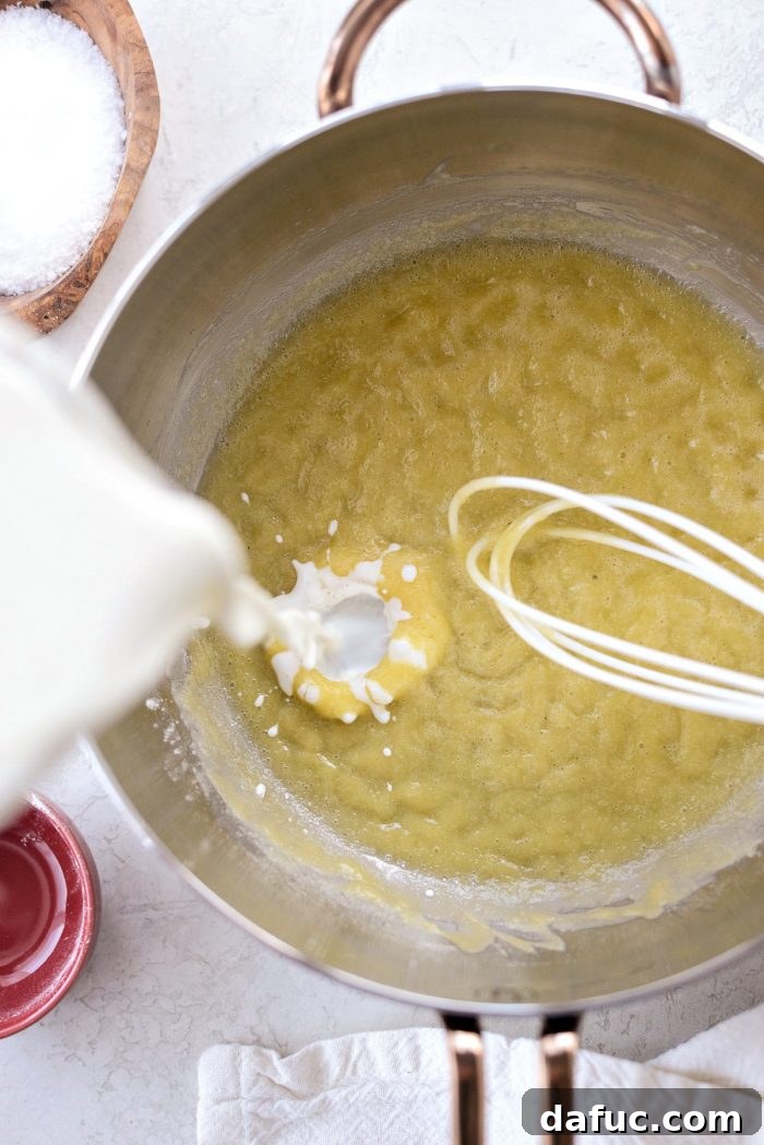 Opulent Lobster Mac and Cheese 11 Whisking flour and melted butter to create a smooth roux in a saucepan.