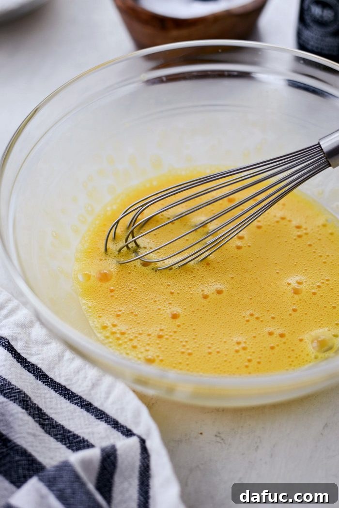Two whole eggs and two separate egg yolks in a bowl, ready for whisking