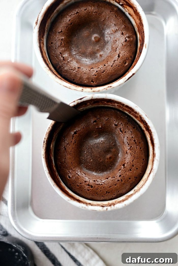 Running a thin knife around the inner edge of a lava cake in a ramekin to loosen it for unmolding