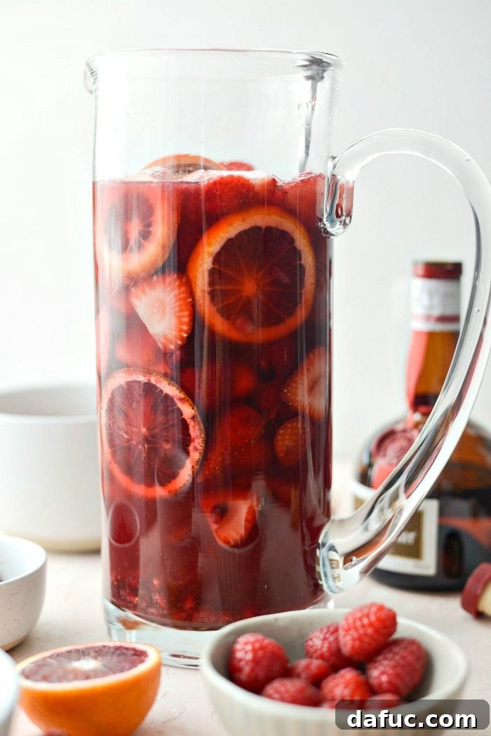 Gently stirring the Champagne Sangria in a large pitcher with a cocktail spoon, ensuring the fruit and liquids are well combined.