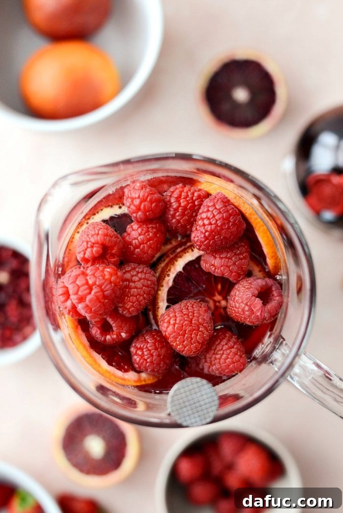 Overhead view of Champagne Sangria in a pitcher, featuring a generous amount of fresh fruit and vibrant color.