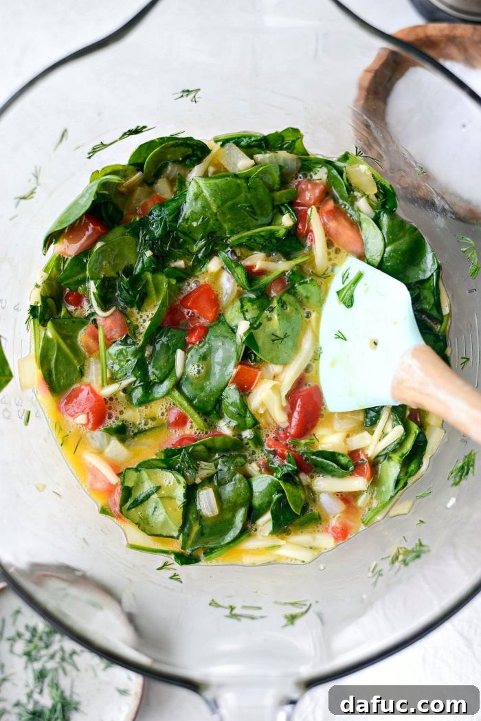 Cooled spinach mixture, Fontina cheese, and fresh dill added to beaten eggs.