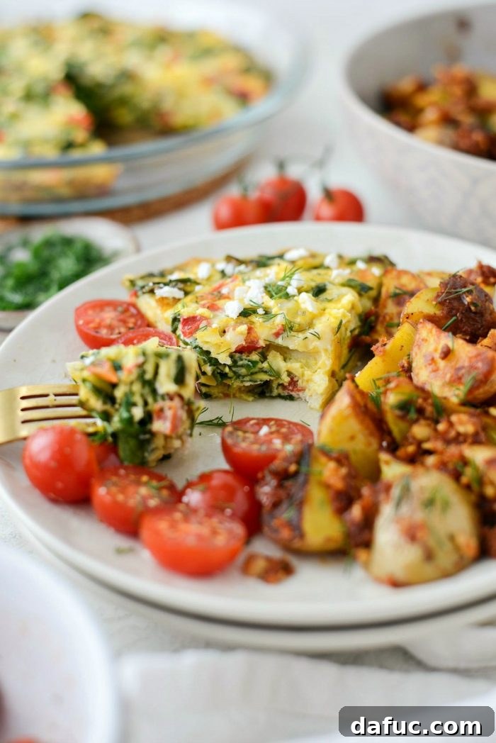 Close-up of a slice of healthy Tomato Spinach and Feta Crustless Quiche, ideal for meal prep.