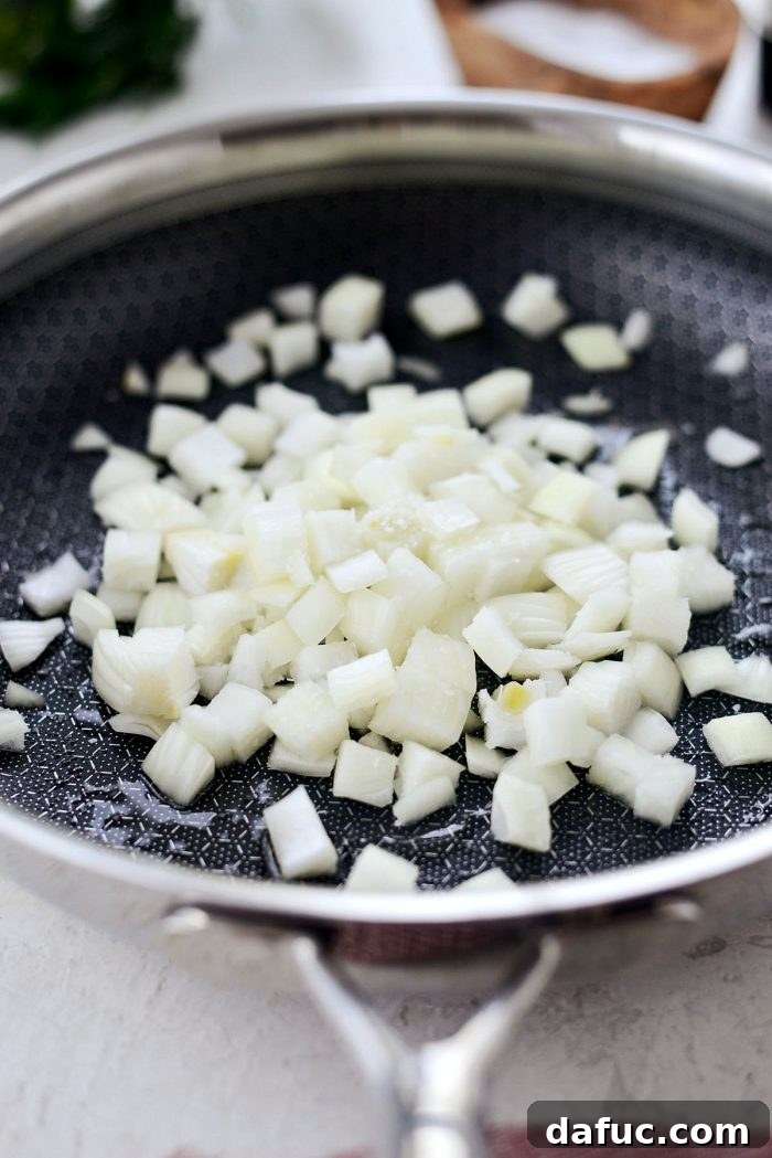 Diced onions and garlic sautéing in a skillet for the quiche filling.