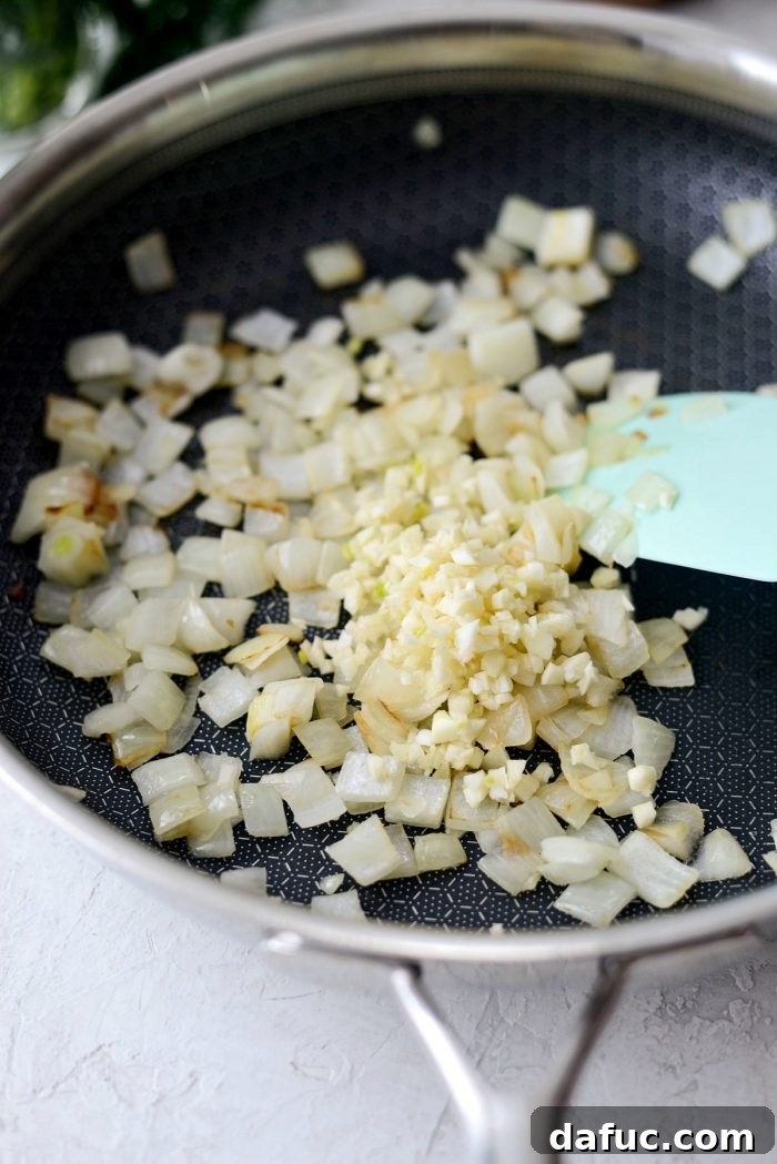Onions sautéing until translucent in a non-stick skillet.