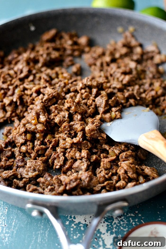 Adding spices like chipotle, chili powder, and cumin to the beef filling for Easy Beef Street Tacos. SimplyScratch.com recipe.