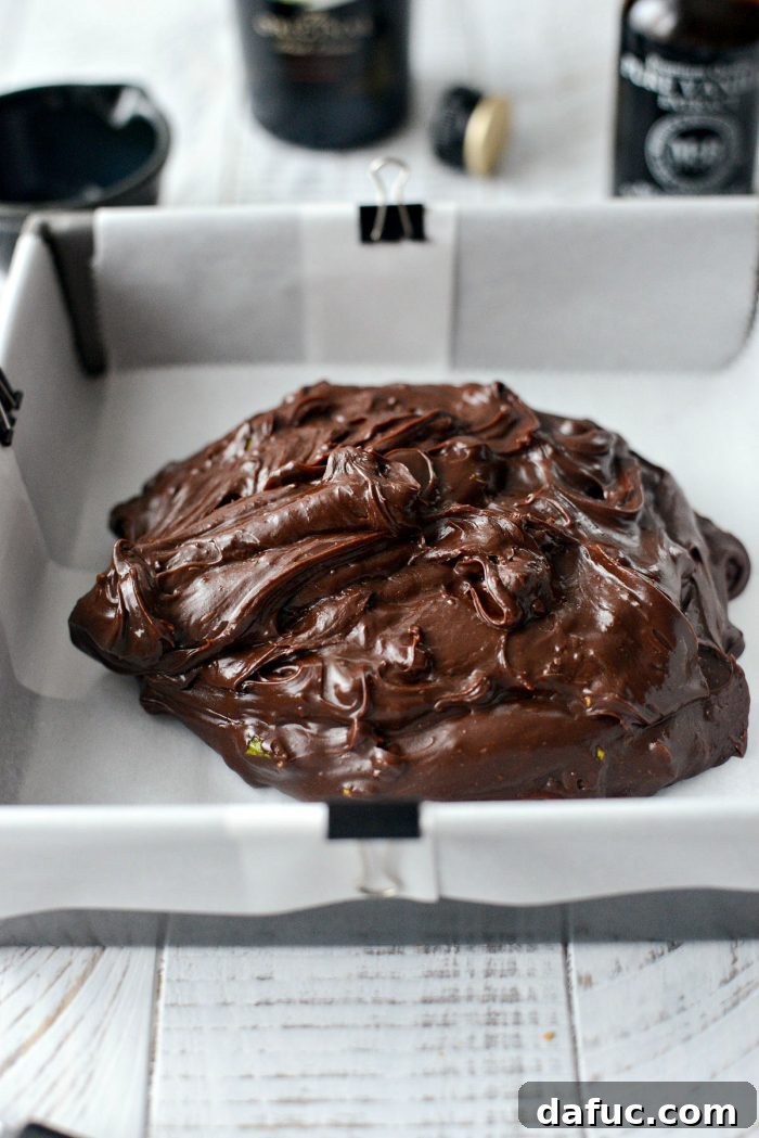 A spoon in a bowl of freshly mixed Baileys Chocolate Pistachio Fudge before chilling.