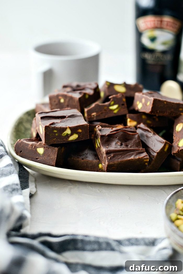 A stack of Baileys Chocolate Pistachio Fudge squares on a plate.