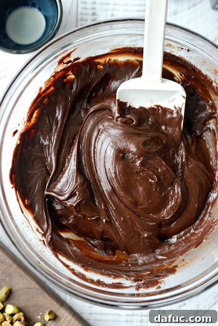 Baileys Irish Cream and vanilla extract being poured into the chocolate mixture.