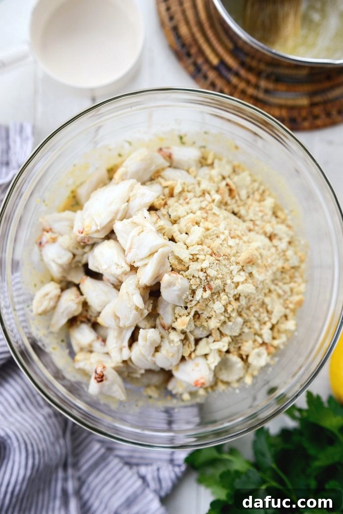 Golden Baked Maryland Crab Delights 11 Jumbo lump crab meat and crushed crackers added to the wet ingredients in a large bowl.