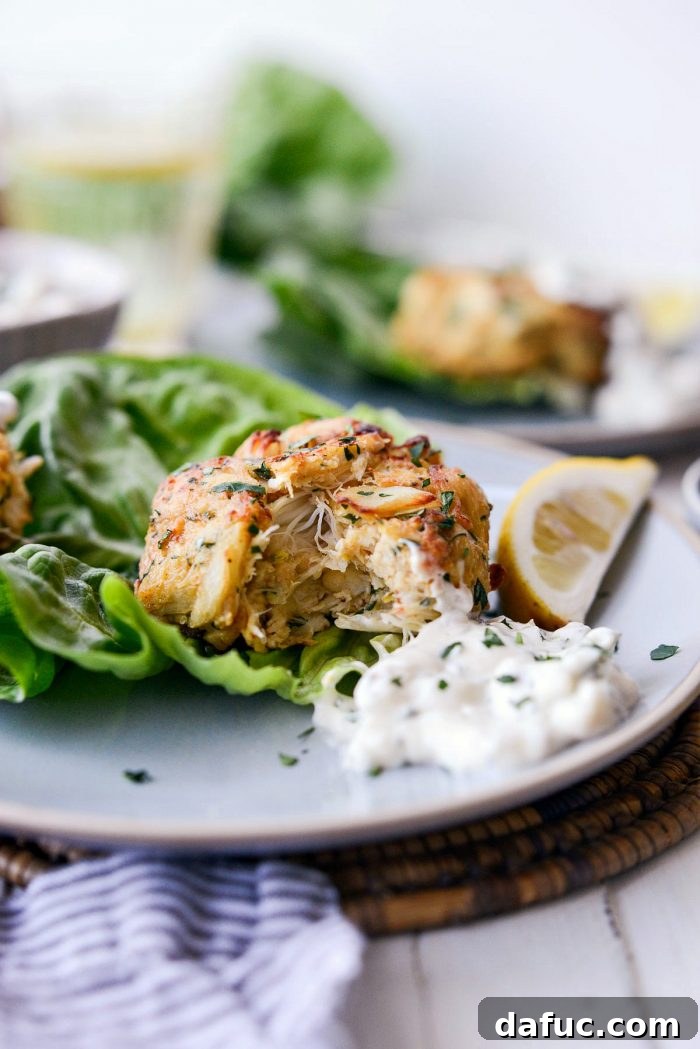 Golden Baked Maryland Crab Delights 23 A final, close-up shot of a perfectly baked Maryland crab cake with a side of creamy tartar sauce.