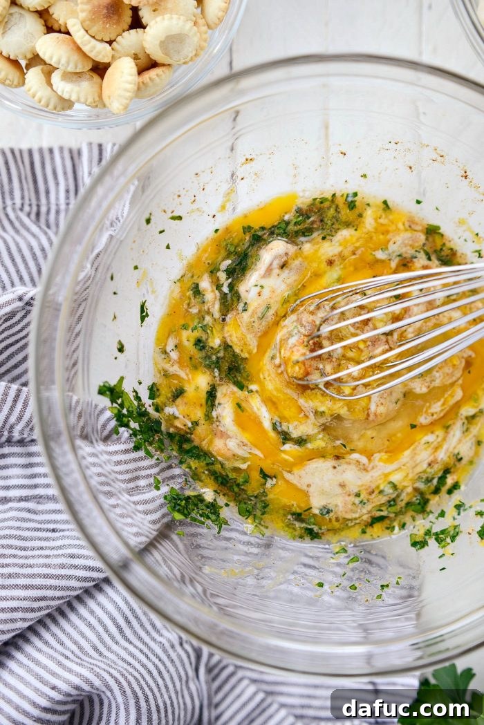 Golden Baked Maryland Crab Delights 9 Wet ingredients for crab cakes being vigorously whisked together in a mixing bowl.